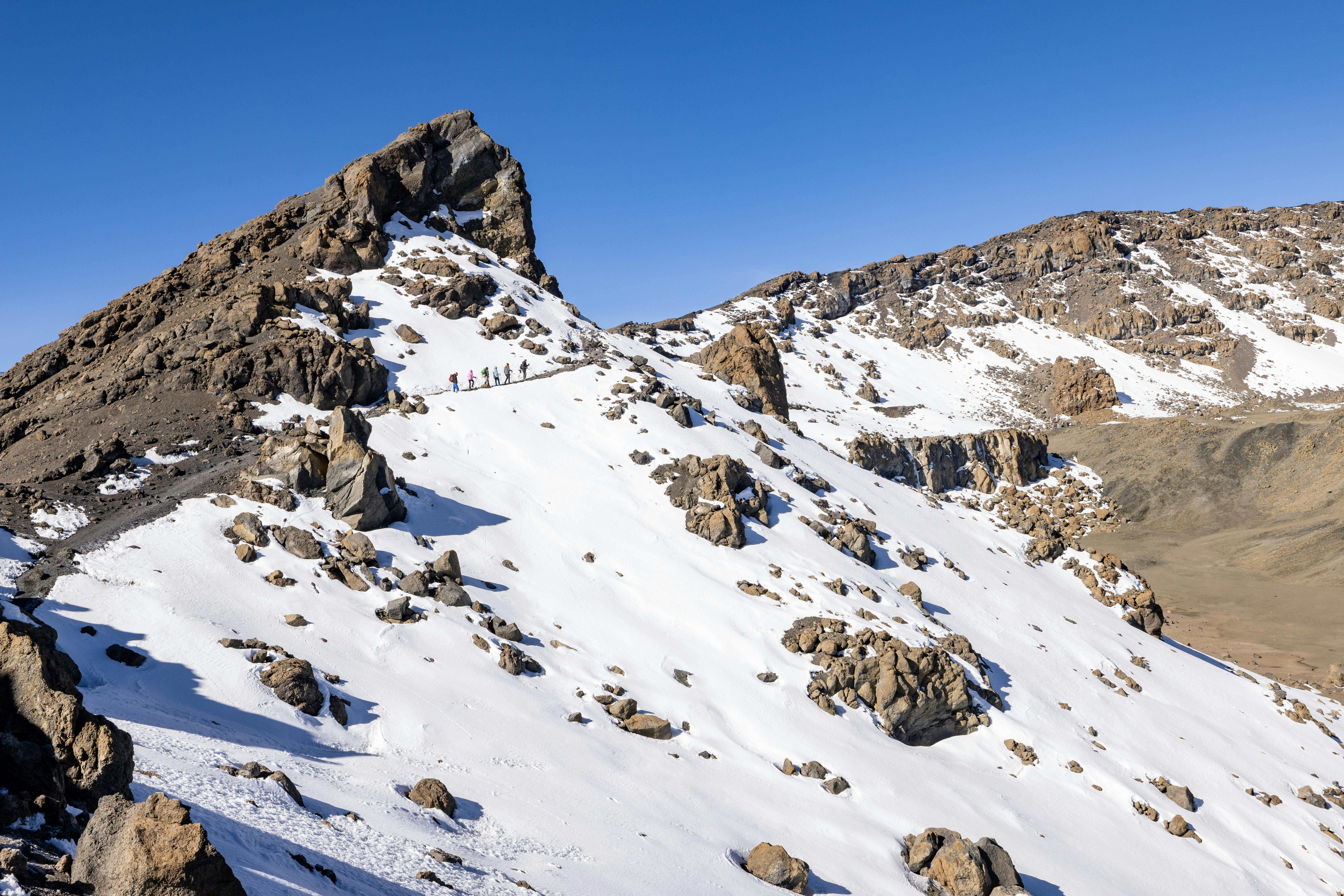 Snow-covered Kilimanjaro mountain with hikers trekking